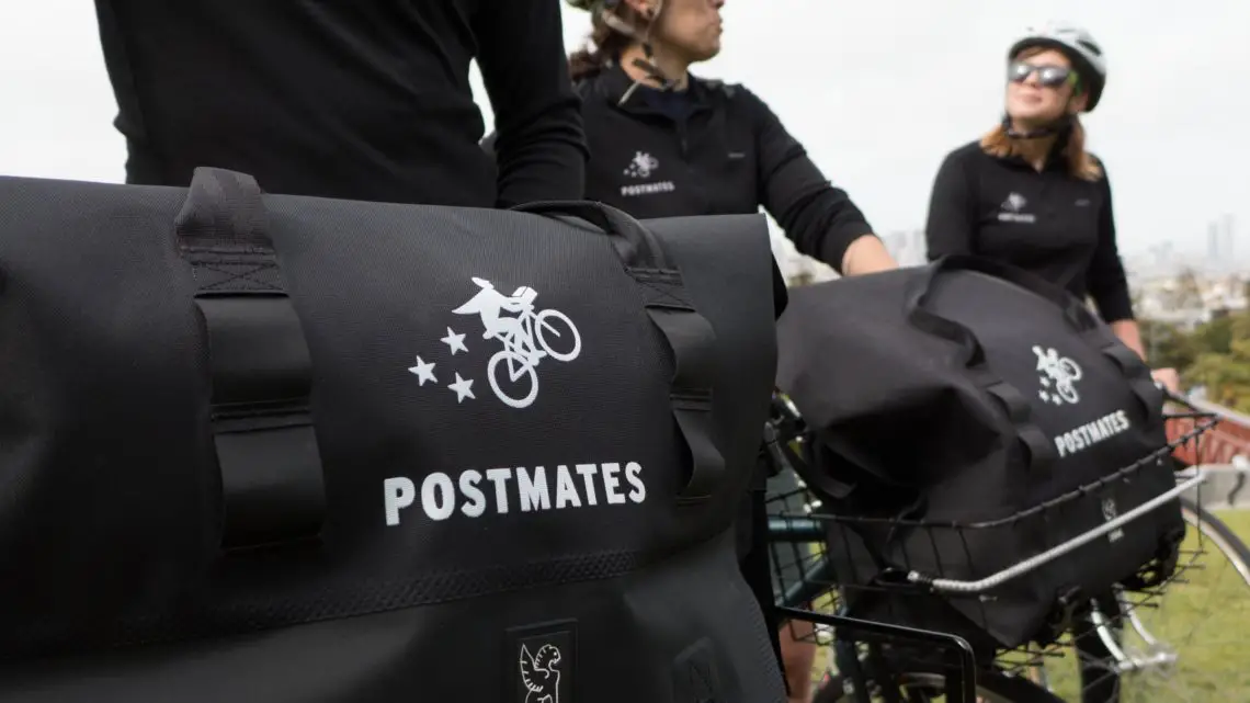 Postmates delivery drivers on bicycles in an urban area